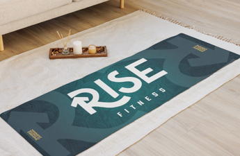 Custom Rise Fitness yoga mat laying on the ground, next to candles.